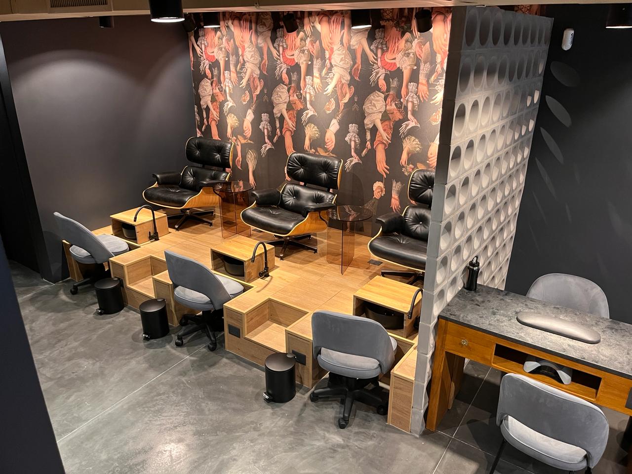 Salón principal de manicura en Obby Studio Libertador con sillas de terciopelo verde y olivo decorativo